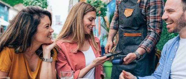 A woman tapping her RemServ Wallet on an EFTPOS machine after dining - RemServ Salary Sacrifice